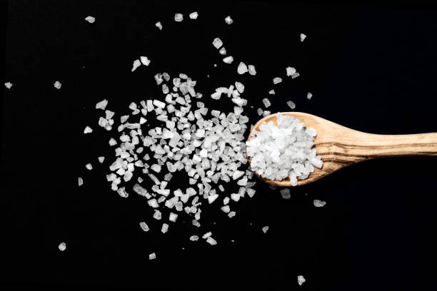 Wooden spoon with salt on black background - Image stock photo