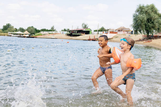 istock Playful boys having fun while running  through water in summer day. 1162341801