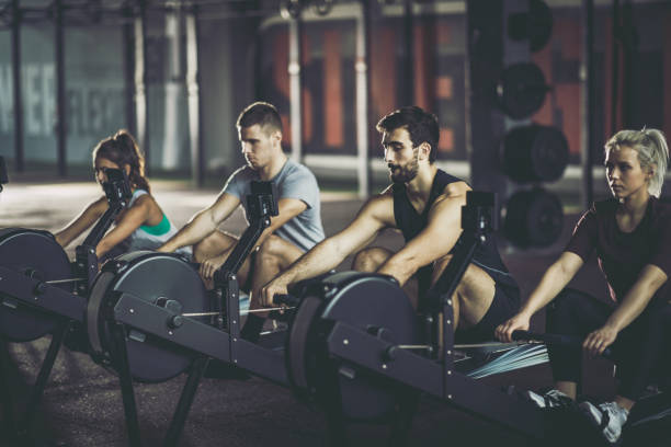 istock Group of athletes exercising on rowing machines in a gym. 1162342800