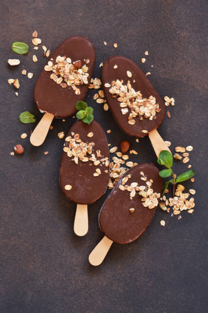 istock Chocolate popsicle with granola and nuts. Ice cream on a concrete background. Top view. 1162342865