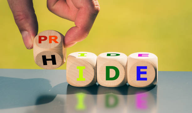 coming out concept. hand turns a cube and changes the word "hide" to "pride". - appears imagens e fotografias de stock