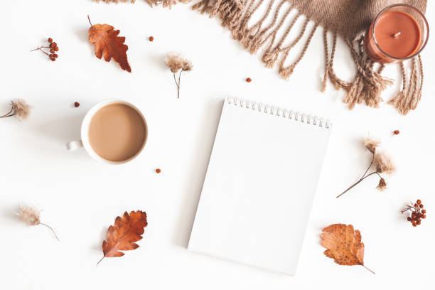 istock Autumn composition. Cup of coffee, plaid, notepad, autumn leaves on white background. Flat lay, top view, copy space 1162345010