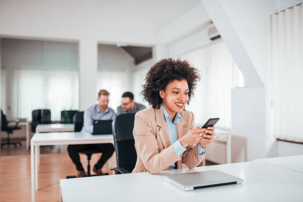 istock Confident young woman using phone at her workplace. 1162346169