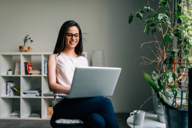 istock Smiling young woman using laptop. 1162346298