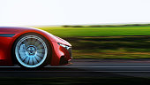istock red car driving on a road 1162347975