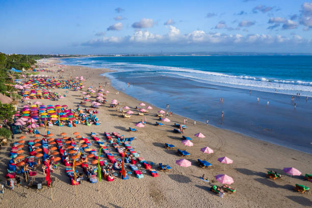 On the west coast of Bali in Indonesia, numerous touristic bars and restaurants face the Indian ocean where people attend the beach to watch the famous sunset.
