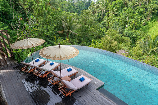 Vista del agua de la piscina y tumbonas en la selva tropical cerca de Ubud, Bali, Indonesia, vista superior photo