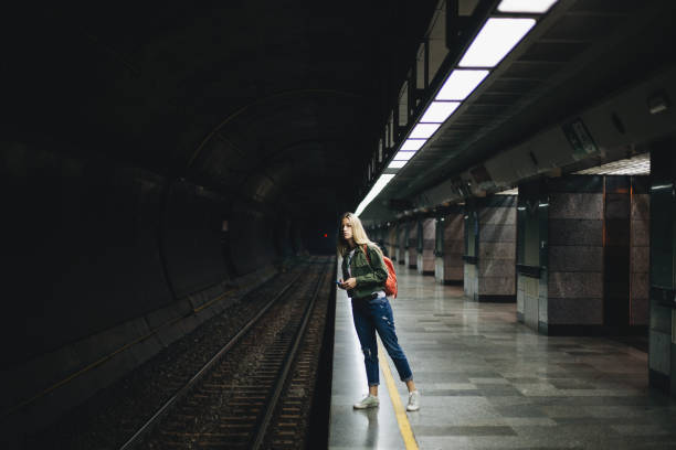 istock Student girl waiting for a train at the subway 1162352020