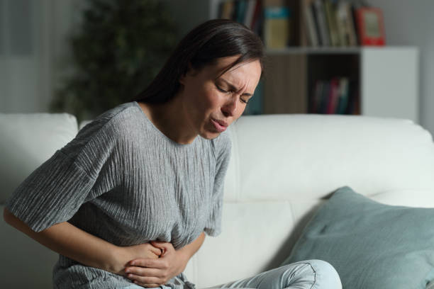 mulher em casa que sofre a dor de barriga na noite - blood disease - fotografias e filmes do acervo