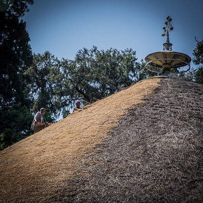 Gondar city. Roof with an ornament on the top. Two people.