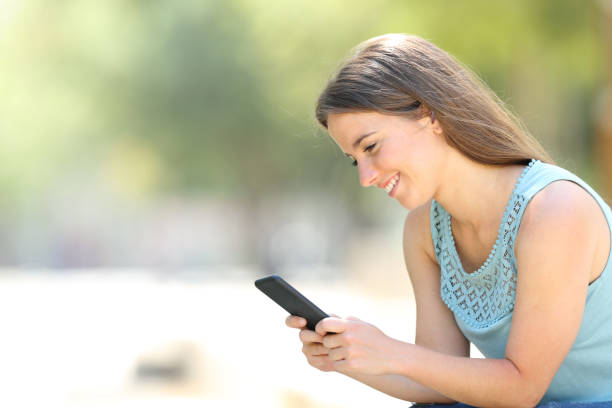 istock Happy woman checking phone online content in a park 1162359444