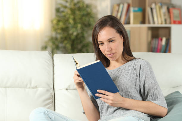 istock Serious woman at home reading a paper book 1162360367