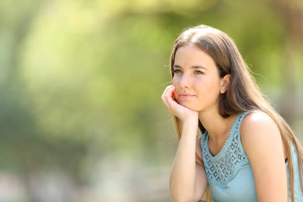 istock Serious woman meditating looking away in a park 1162360867