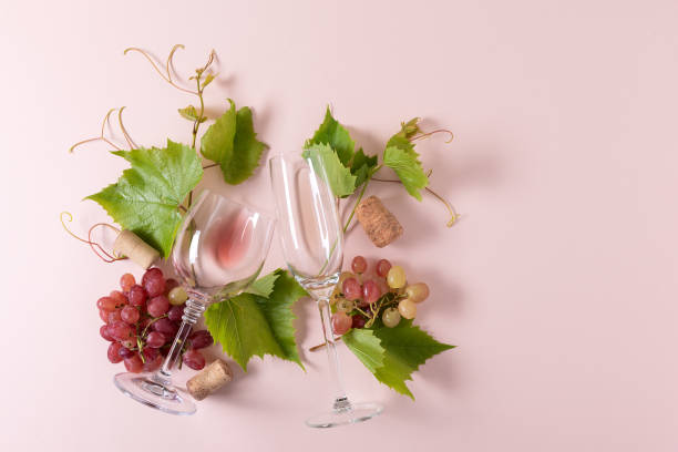 istock Assorted wineglasses with rose and white wine, grape, leaves and cork lying on pink background. Wine degustation concept. Flat lay. Top view. Copy space 1162361097