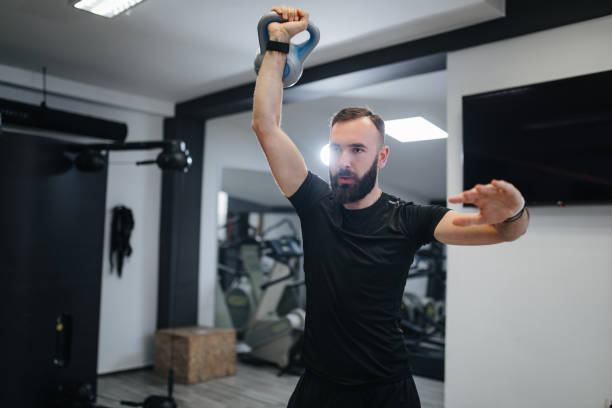 istock Muscular man raising kettle bell above his head 1162361964