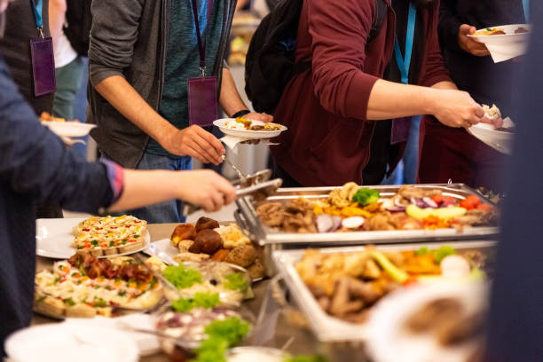 People enjoying buffet meal. Close up of people serving themselves with canapes in buffet of restaurant. food service occupation food and drink industry party buffet stock pictures, royalty-free photos & images