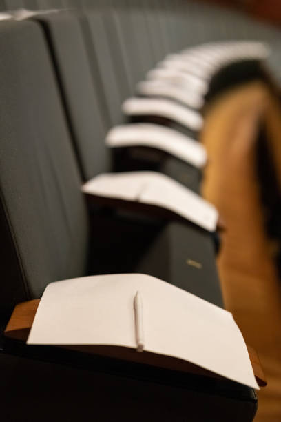 istock Exam paper sheet tests with pen on seats. University concept. 1162362343