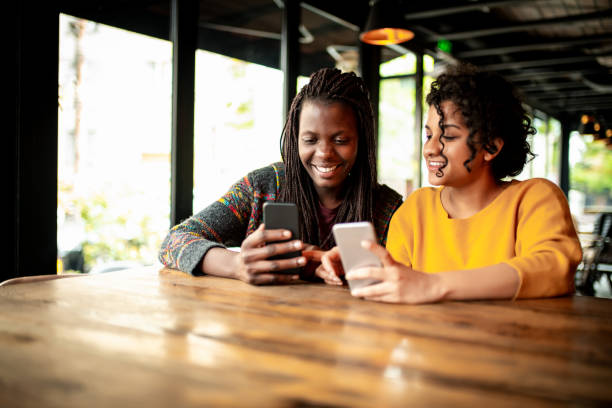 istock Two millenial friends using mobile phone. 1162365439