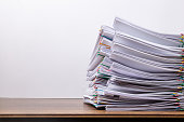Stack of document paper with colorful paperclip place on wooden table, business concept paperless used and work overload .