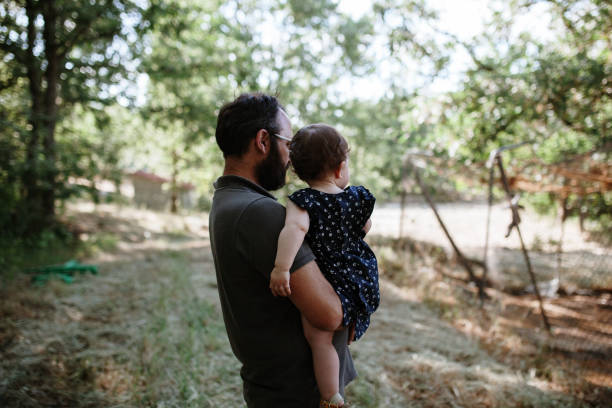 istock Side View Of Man Holding Daughter While Standing On Field 1162371200