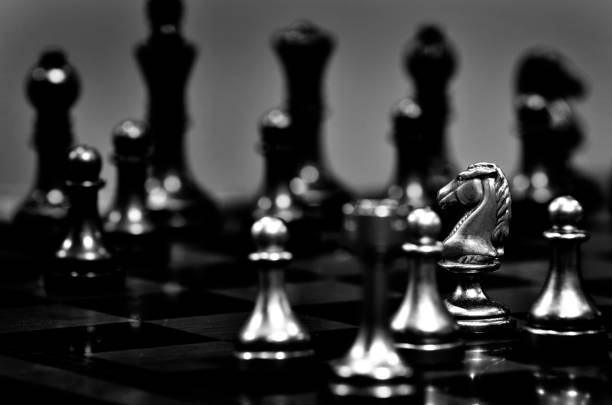 istock Chess board with white knight facing opponent in match 1162371595