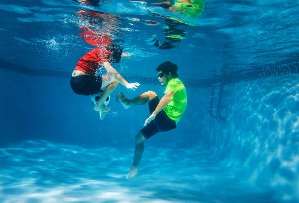 istock Kids playing underwater soccer 1162373619