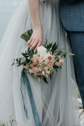 Close-up bride holds in hands a beautiful wedding bouquet. Wedding celebration.