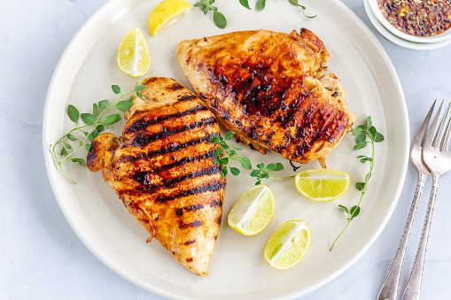 Healthy Grilled Chicken Breast with Fresh Herb Directly from Above Photo. Cooked Chicken Breast in a White Plate and 