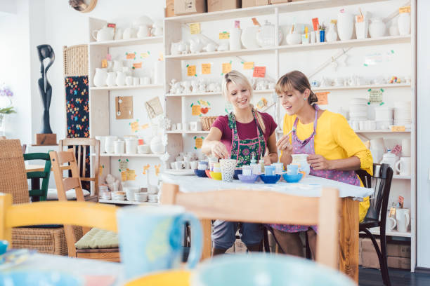 istock Women friends looking at lots of self-made tableware in workshop 1162386022