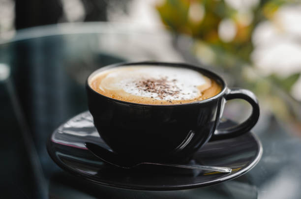 istock close up modern hot black coffee the cappuccino on dark background with coffee bubble foam pattern and texture in black cup looking and feel so delicious on glasses table in coffee shop. 1162390924