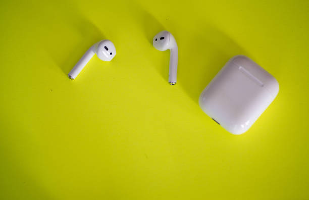 istock Wireless earbuds isolated against yellow background 1162392639