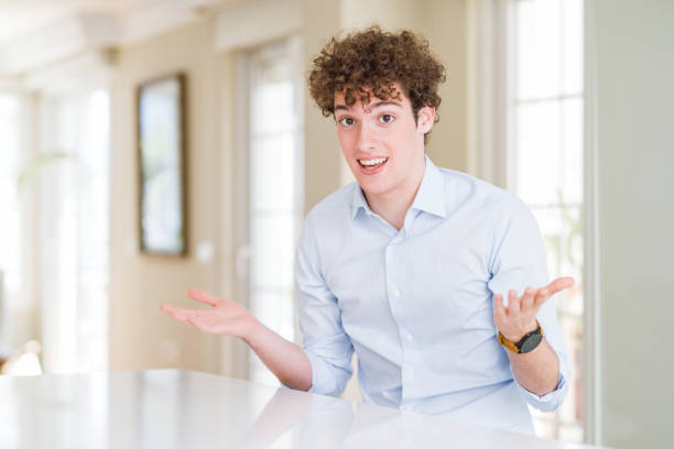 istock Young business man with curly read head smiling cheerful with open arms as friendly welcome, positive and confident greetings 1162392731