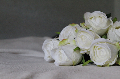 Floral ornamentation inside a worship space, church. Festive decoration for wedding event. Flower arrangements predominantly white and green. Selective focus