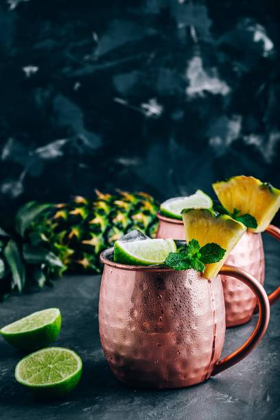 istock Iced Cold Moscow Mule cocktail with lime and pineapple on dark background 1162395217