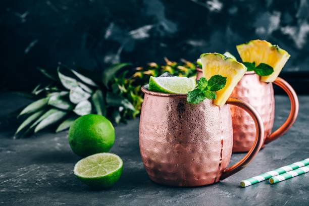 istock Iced Cold Moscow Mule cocktail with lime and pineapple on dark background 1162395235