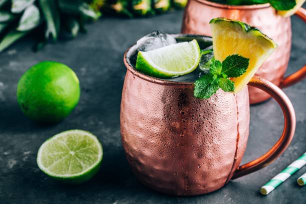 istock Iced Cold Moscow Mule cocktail with lime and pineapple on dark background 1162395238