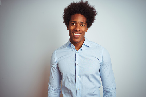 Young african american man with afro hair wearing elegant shirt over isolated white background with a happy and cool smile on face. Lucky person.