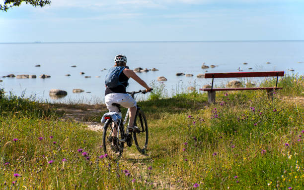 istock Woman bicycling on sea shore 1162400470