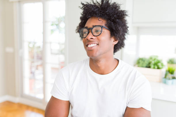 afroamerikanischer mann trägt brille lächelnd seite und starrt weg denken. - staring black and white glasses human face stock-fotos und bilder