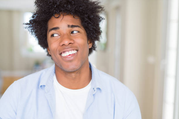 istock African American man at home smiling looking side and staring away thinking. 1162402375