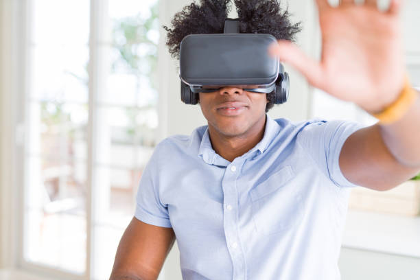 istock African amaerican man having fun playing with virtual reality glasses 1162403203