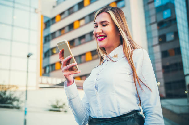 istock Smiling Woman walking and using phone 1162403300