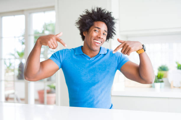istock African American man at home looking confident with smile on face, pointing oneself with fingers proud and happy. 1162404105