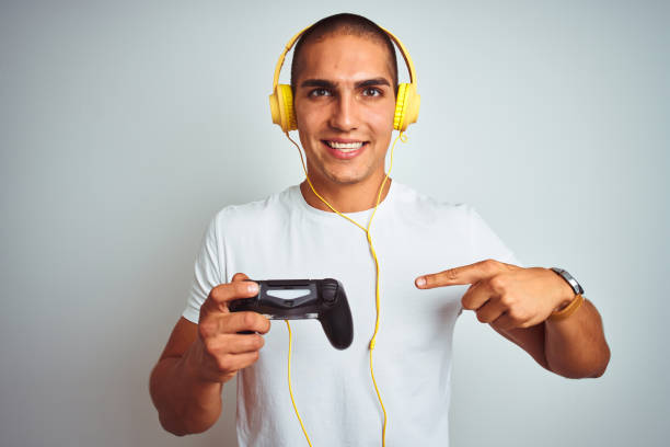 istock Young handsome man playing videogames using headphones over white isolated background very happy pointing with hand and finger 1162406657