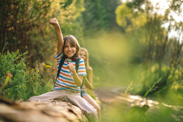 istock Boy and girl playing and riding tree trunk 1162407945