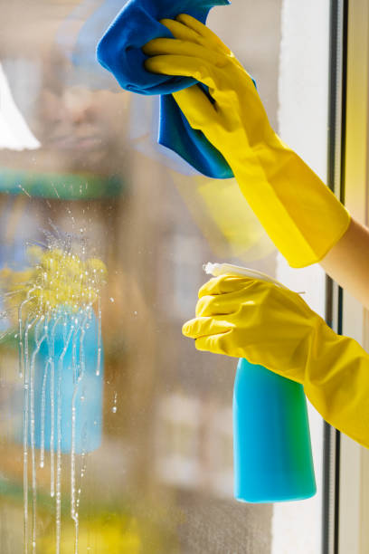 istock Gloved hand cleaning window rag and spray 1162408578