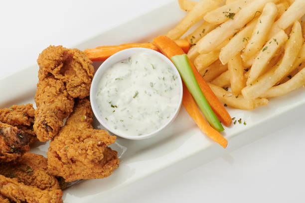 Creamy sauce with fried chicken and fries on plate