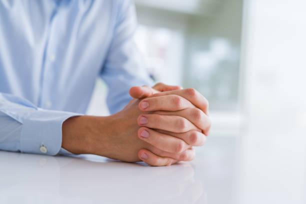 istock Close up of man crossed hands over white table 1162409721