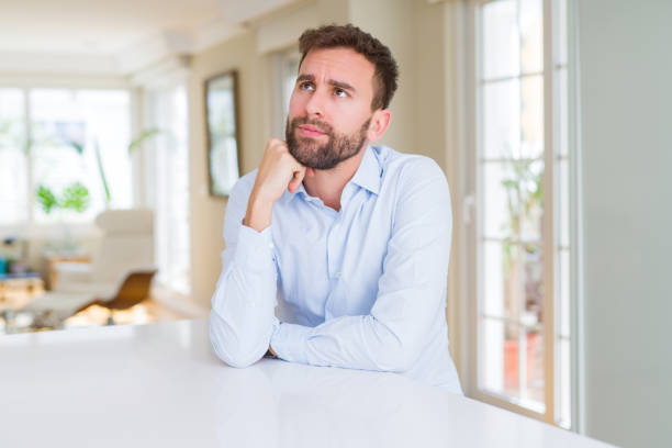 istock Handsome business man with hand on chin thinking about question, pensive expression. Smiling with thoughtful face. Doubt concept. 1162409732