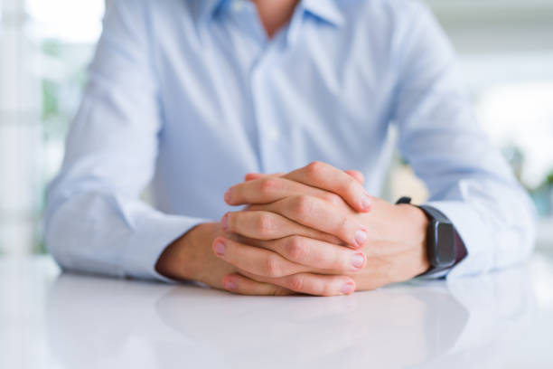 istock Close up of man crossed hands over white table 1162409875